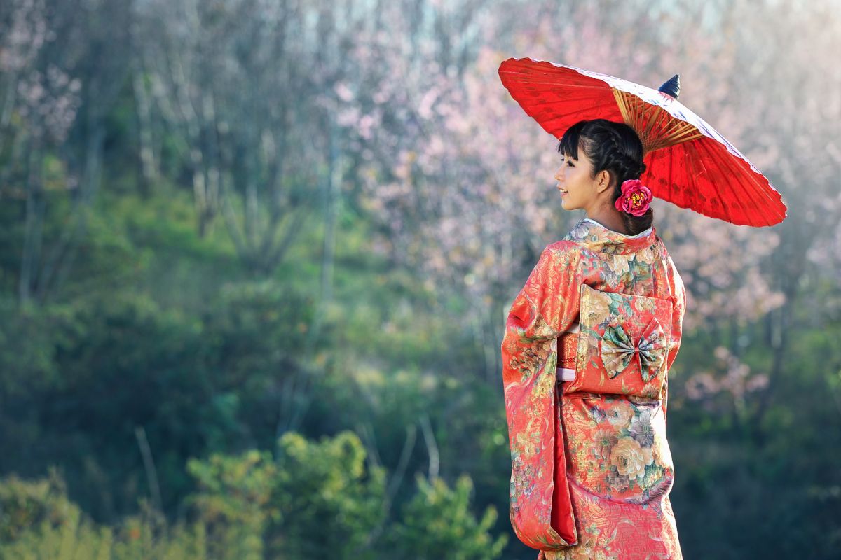 chunka ubrana w kimono stojaca pod parasolem