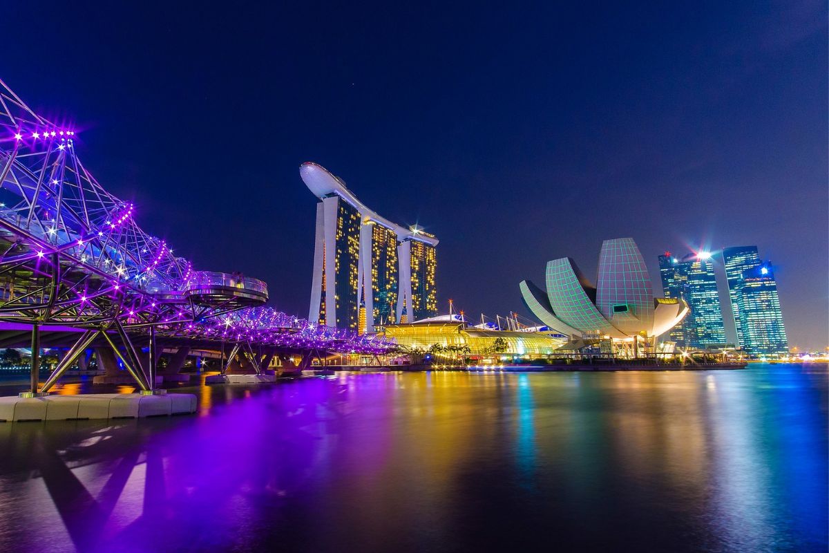 Widok na oświetlone w nocy nowoczesne budynki Singapuru nad Marina Bay